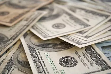 Scattered U.S. dollar bills in various denominations.