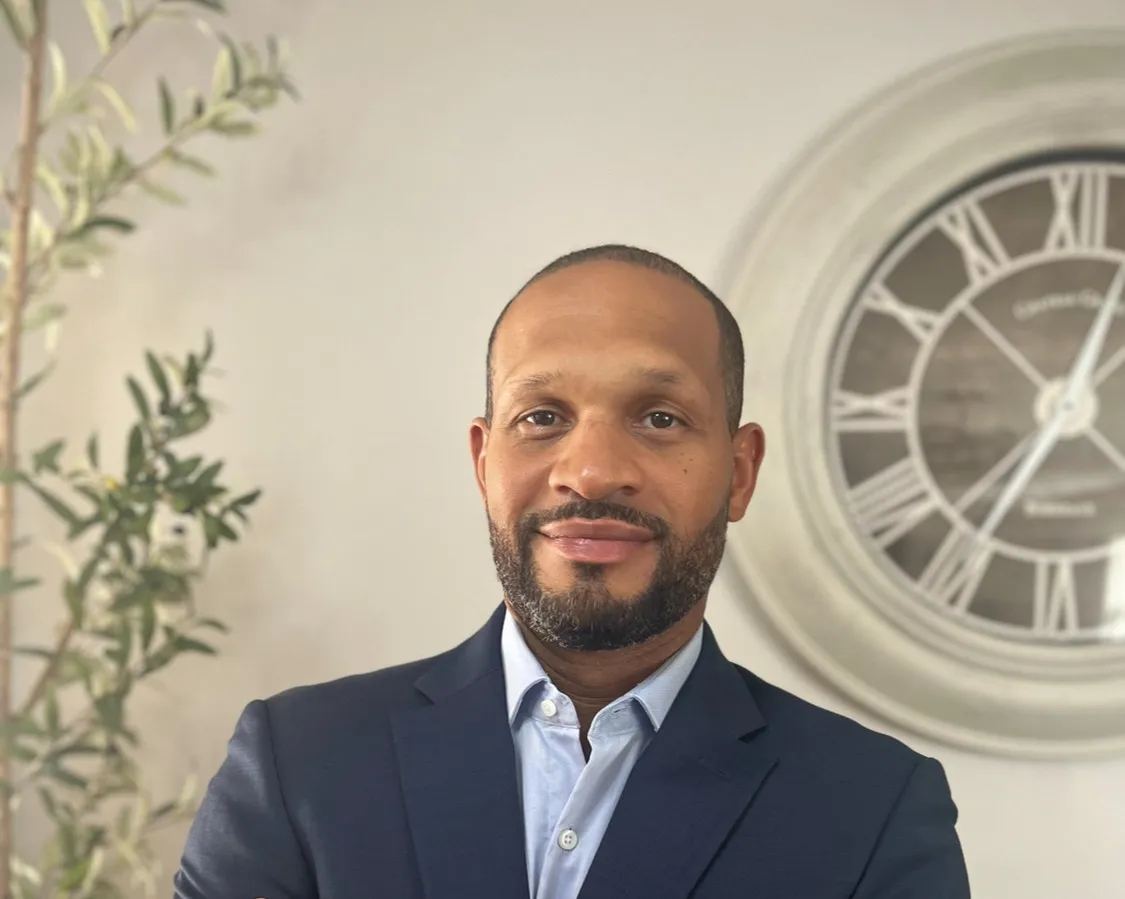 Man in suit with large wall clock.