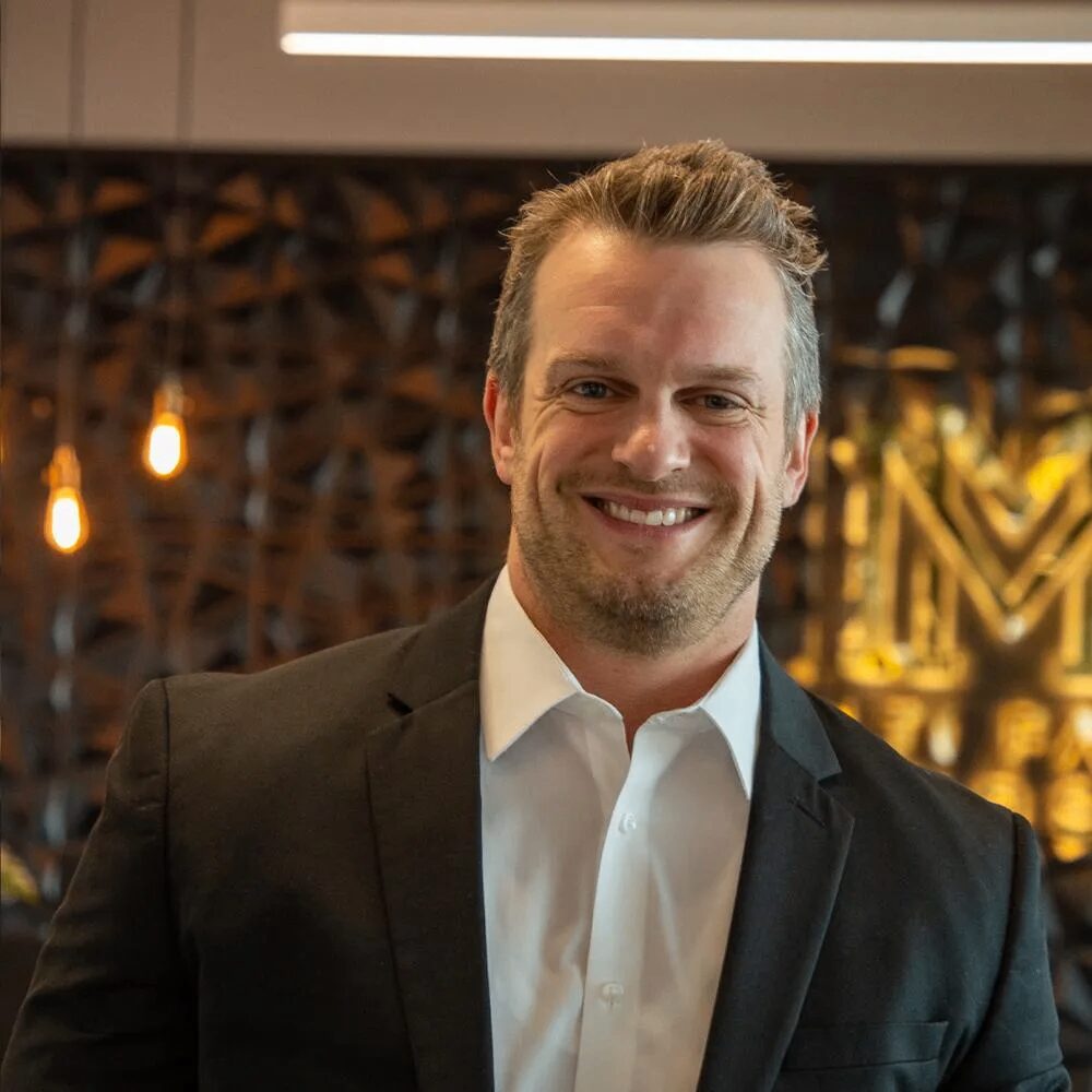 Smiling man in a suit indoors.