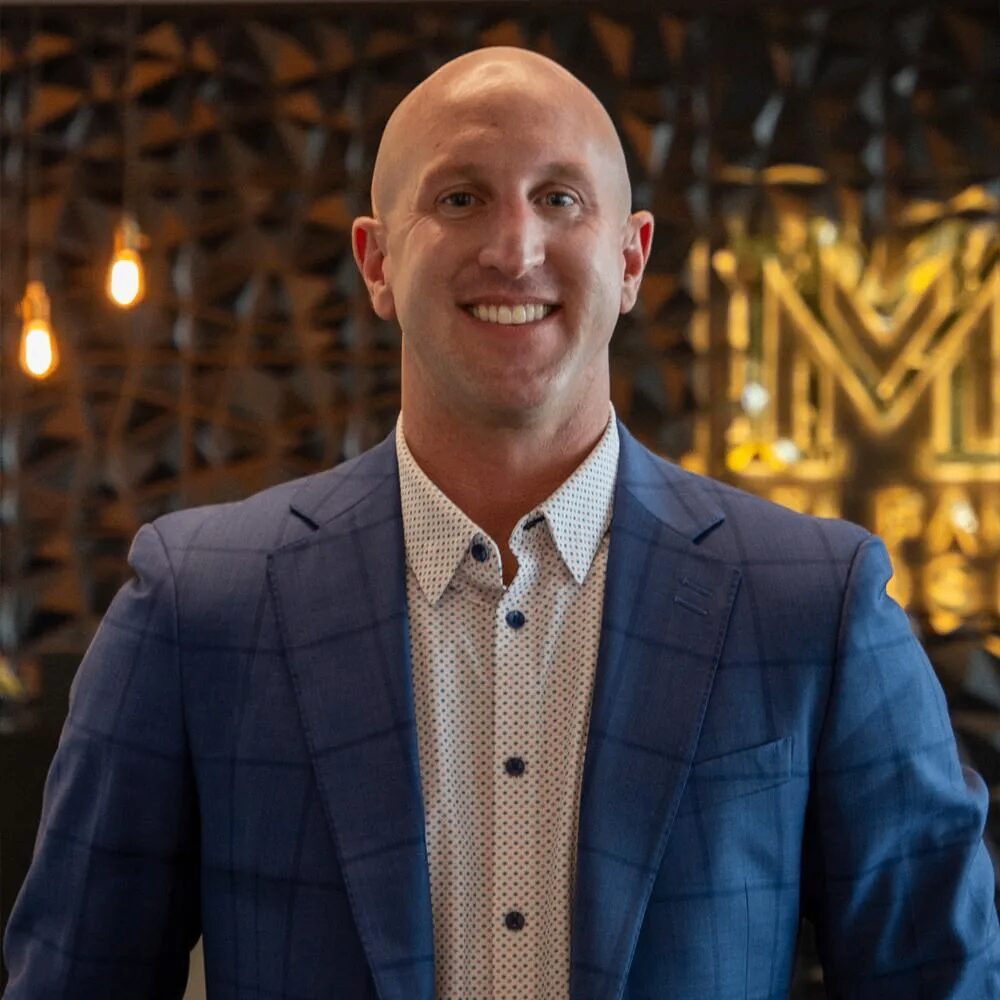Smiling man in a blue suit jacket.