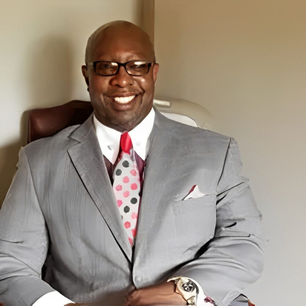 Smiling man in gray suit and tie.