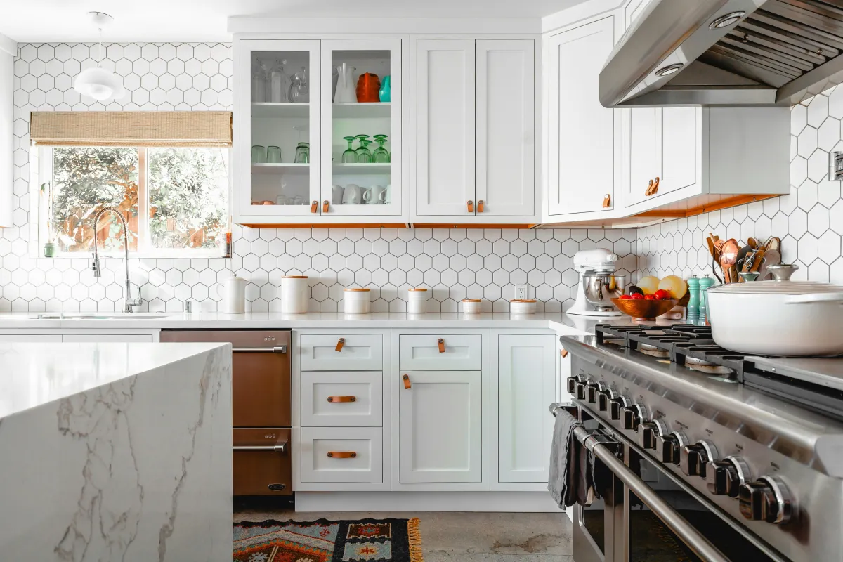 Modern kitchen with white cabinets and appliances.